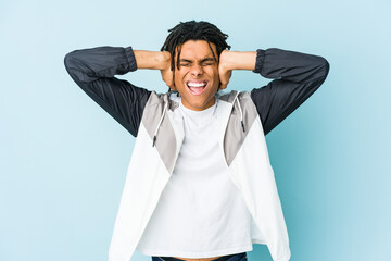 Young african american sport man covering ears with hands trying not to hear too loud sound.