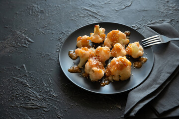 Buffalo barbecue cauliflower on dark background. Top view. Summer food concept