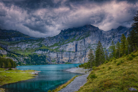 lake in the mountains - Oschinensee is part of the Jungfrau-Aletsch-Bietschhorn UNESCO World Heritage Site. The lake is frozen in winter people will come for ice skating on the lake..