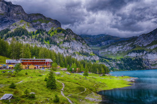 lake in the mountains - When you hike up to Oschinensee this is the view you'll see, green grass, alpine trees, a beautiful blue lake, and a Swiss chalet in the high country