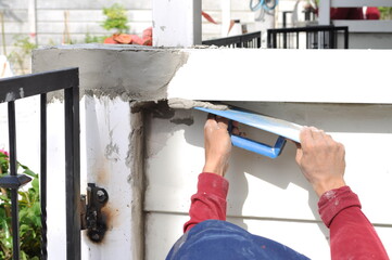 Construction worker, wall plastering trowel repair cracks
