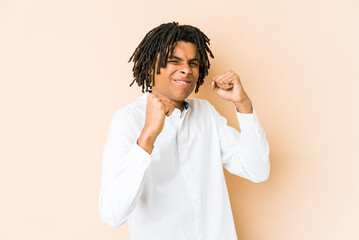 Young african american rasta man showing fist to camera, aggressive facial expression.