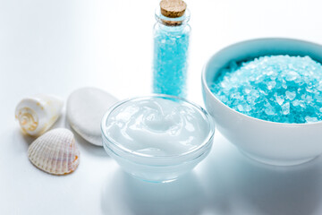 Obraz na płótnie Canvas blue sea salt and body cream on white desk background