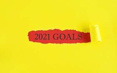 The text 2021 Goals appearing behind torn color paper.The concept of achieving business goals. Execution of a business plan. Purposefulness. Planning.Strategy and management