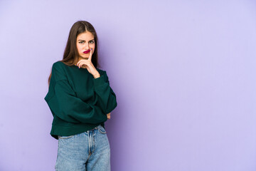 Obraz premium Young caucasian woman isolated on purple background unhappy looking in camera with sarcastic expression.