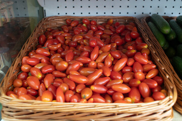 Cherry tomatoes in a basket on the counter of the store.