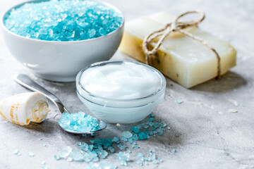 Fototapeta na wymiar blue set for bath with salt and shells on stone table background