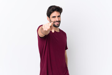 Young handsome man with beard over isolated white background points finger at you with a confident expression