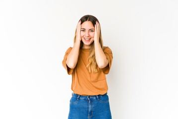 Young caucasian woman isolated on white background having fun covering half of face with palm.