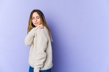 Young caucasian woman isolated on purple background having a shoulder pain.