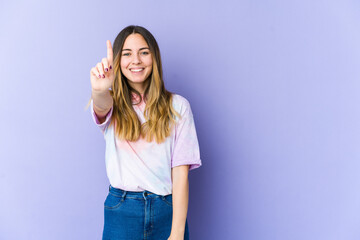 Young caucasian woman isolated on purple background showing number one with finger.