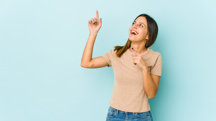 Young woman isolated on blue background dancing and having fun.