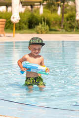 The boy plays with a water gun