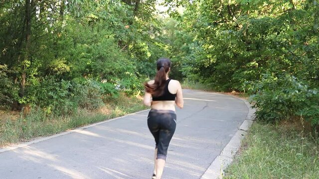 A girl runs in the woods. Exercise for weight loss and healthy lifestyle, cardio.