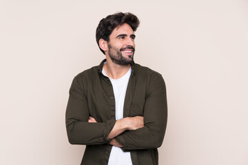 Young handsome man with beard over isolated background happy and smiling
