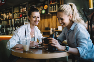 Female friends watching photos on camera together