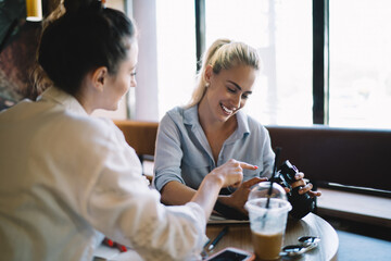 Cheerful women chatting together in cafe