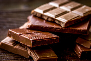 black and milk chocolate bars dark wooden table background