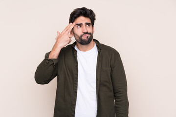 Young handsome man with beard over isolated background with problems making suicide gesture