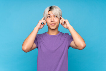 Young asian man over isolated blue background having doubts and thinking