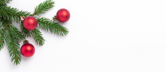 Naklejka na ściany i meble Christmas horizontal banner. Fir tree branches with red christmas balls on white background. Top view. Copy space