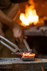 blacksmith working metal on the anvil in the forge