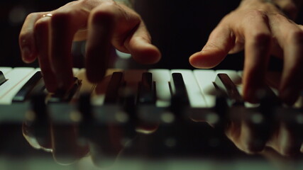 Musician making music in dark hall Man hands pressing keys on piano indoor. © stockbusters