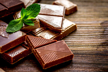 black chocolate design with mint on wooden background
