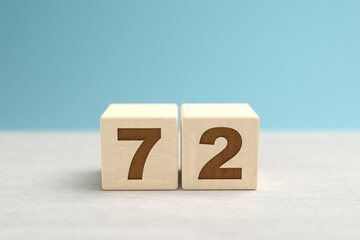 Wooden toy blocks forming the number 72.