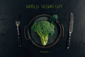 Broccoli and cutlery on a black background. The inscription "World Vegan Day".