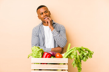 Young farmer man isolated on a beige background relaxed thinking about something looking at a copy space.