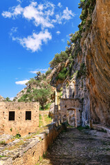 Fototapeta na wymiar Ruins of entrance gate to abandoned Orthodox Katholiko monastery in Avlaki gorge, Akrotiri peninsula, Chania, Crete, Greece. Spring daytime.