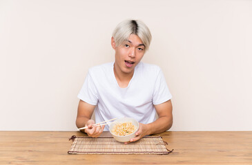 Young asian man with ramen in a table