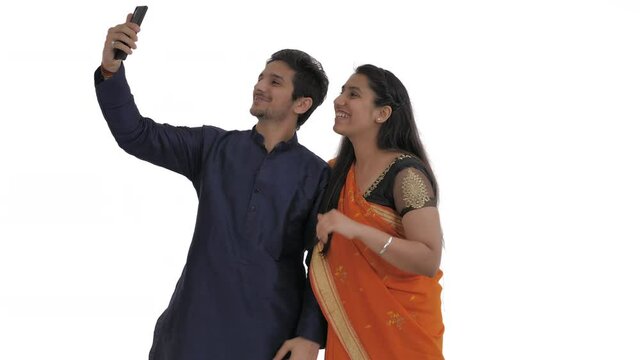 Indian couple having pleasant conversation with friends or relatives by video call. Showing o-key sign, greeting gestures, thumbs up. Common Indian body language concept. Isolated on white background