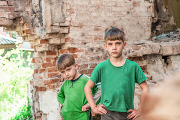 Obraz na płótnie Canvas Two sad and unhappy brothers in a destroyed and abandoned buildi