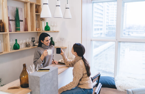 Cheerful Young Ladies Drinking Coffee Together At Home