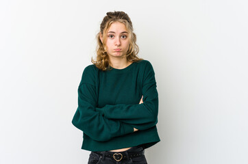 Young caucasian woman on white backrgound shrugs shoulders and open eyes confused.