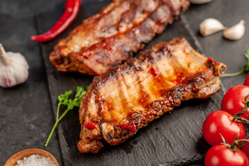 grilled pork ribs with spices on a stone background