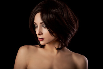 Alluring portrait of short bob hair style woman looking down on black background. Closeup portrait.