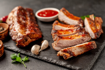  grilled pork ribs with spices on a stone background