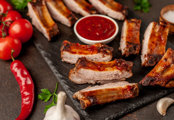 grilled pork ribs with spices on a stone background