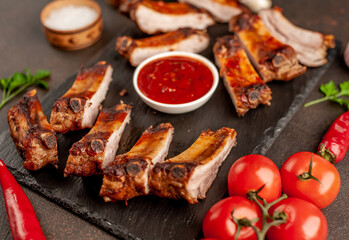grilled pork ribs with spices on a stone background