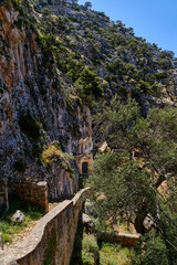Fototapeta na wymiar Ruins of abandoned Orthodox Katholiko monastery in Avlaki gorge, Akrotiri peninsula, Chania, Crete, Greece. Ruins of entrance gate to the area.