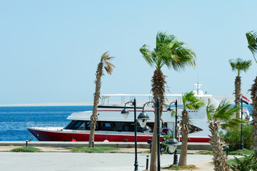 Stone embankment with parked travel speed boat on a water.