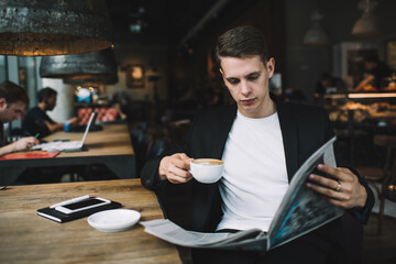 Focused man reading newspaper in cafe