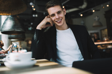 Smiling young male entrepreneur in cafe