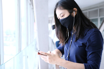 Girl with mask on face,And listening music from smartphone