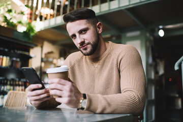 Young man surfing Internet on cellphone