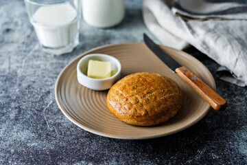 Rye bun in a plate with glasses of milk