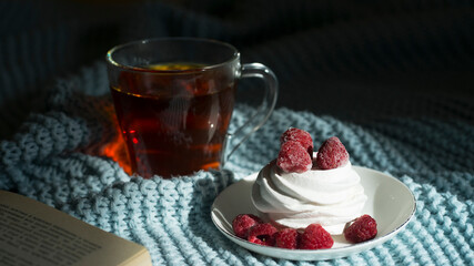 Photo of cozy free time. Book, cup of tea and a beautiful dessert